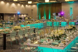 A banquet hall with long tables set for a formal event, featuring clear chairs and floral centerpieces. - Hilton Miami Downtown (Miami)