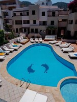 Una piscina al aire libre de temporada, sombrillas