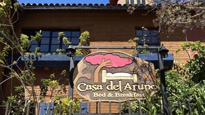 Ein Schild für Casa del Arpe Bed & Breakfast mit rustikalem Design und einem Baummotiv.