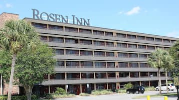 A multi-story hotel with a prominent 'ROSE INN' sign, featuring a modern architectural design with a flat roof and a series of balconies.