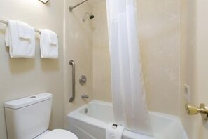 A bathroom with a toilet, a shower with a glass door, and a bathtub. - Rosen Inn International (Orlando)