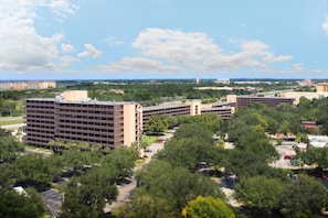 A multi-story parking structure with a central courtyard surrounded by trees.