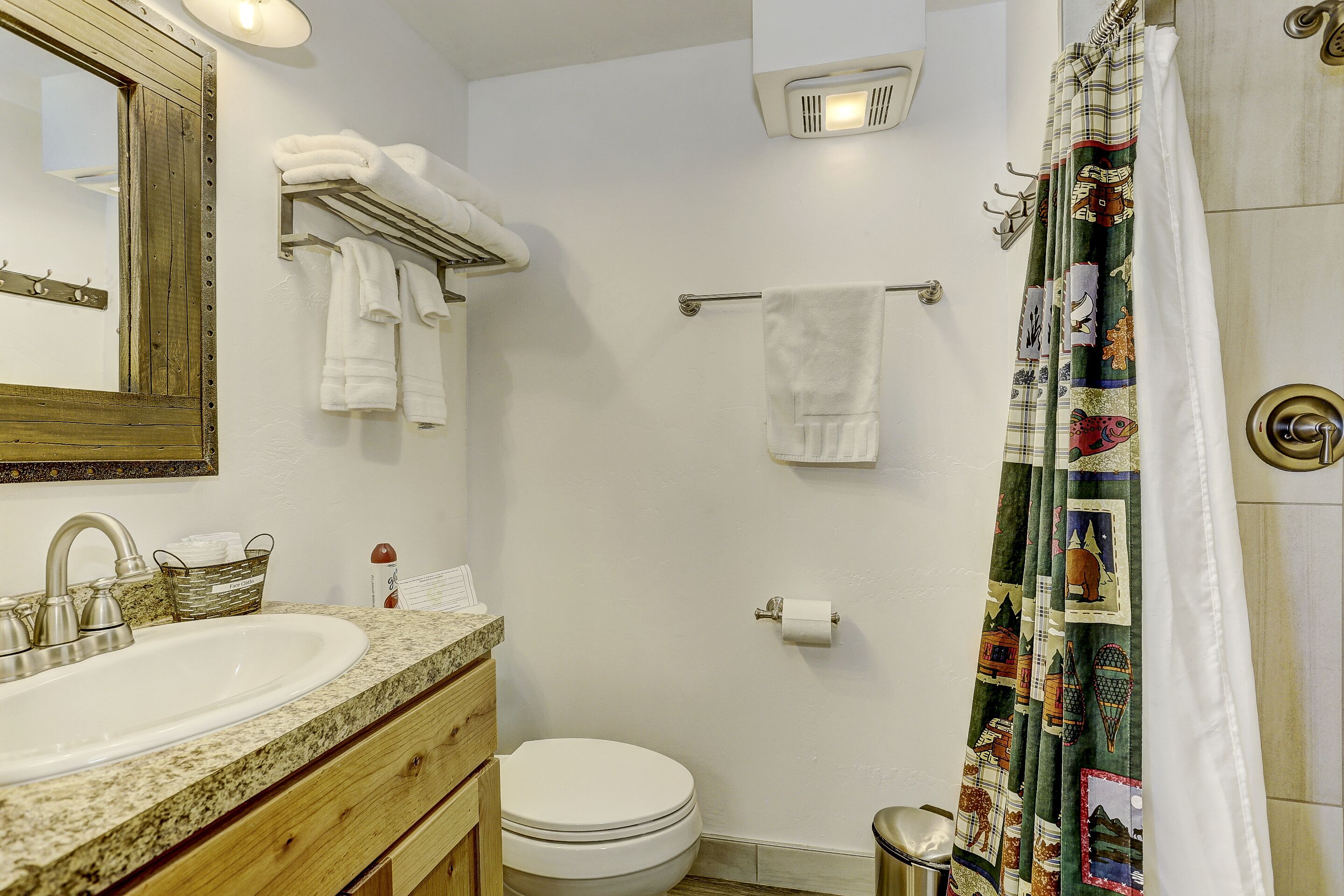 A bathroom with a sink, toilet, and towel rack.