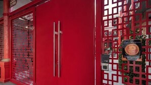 A red door with a metal handle and a decorative metal plate. - Best Western Plus Dragon Gate Inn (Los Angeles)