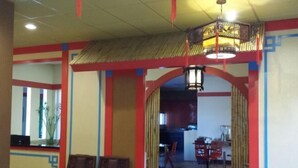 A room with a traditional design, featuring a central archway, a dining area with red chairs, and a small table. - Best Western Plus Dragon Gate Inn (Los Angeles)
