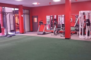 A gym with exercise equipment, a treadmill, and a mirrored wall. - Best Western Plus Dragon Gate Inn (Los Angeles)