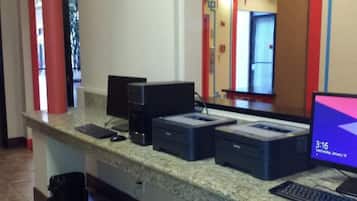 A reception desk with a computer, printer, and keyboard.