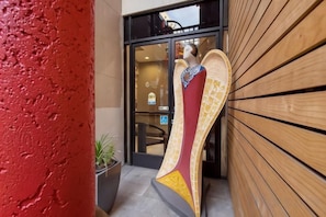 A building entrance with a large, colorful sculpture of a winged figure. - Best Western Plus Dragon Gate Inn (Los Angeles)