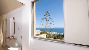 A balcony with a clear view of the sea and a tree. - Antinea Suites And Spa (Santorini)