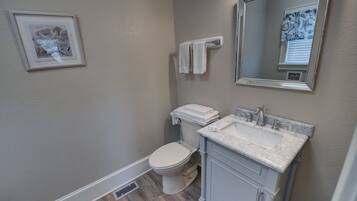 Un baño con inodoro, lavabo y espejo.