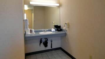 Un bagno d'albergo con lavandino, specchio e articoli da toilette.