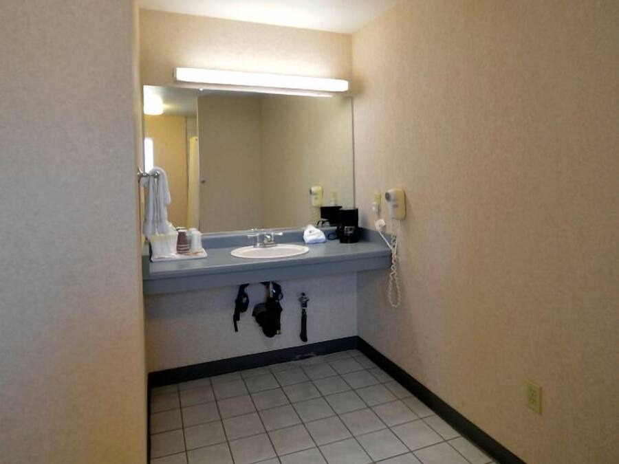 Un bagno d'albergo con lavandino, specchio e articoli da toilette.