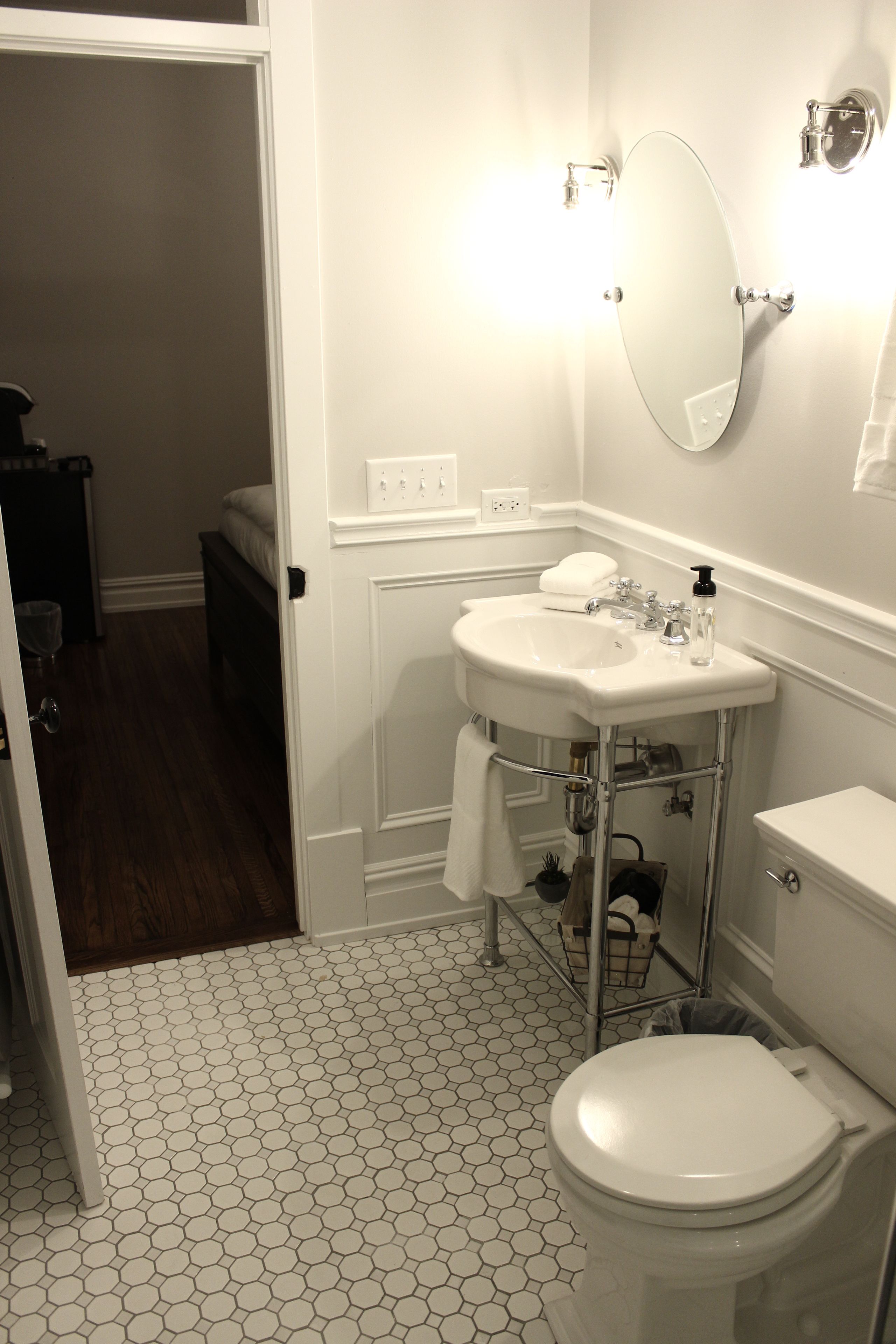 A bathroom with a white toilet, a white sink, and a mirror.