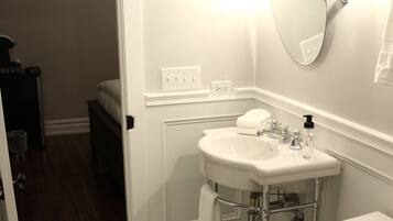 A bathroom with a white toilet, a white sink, and a mirror.