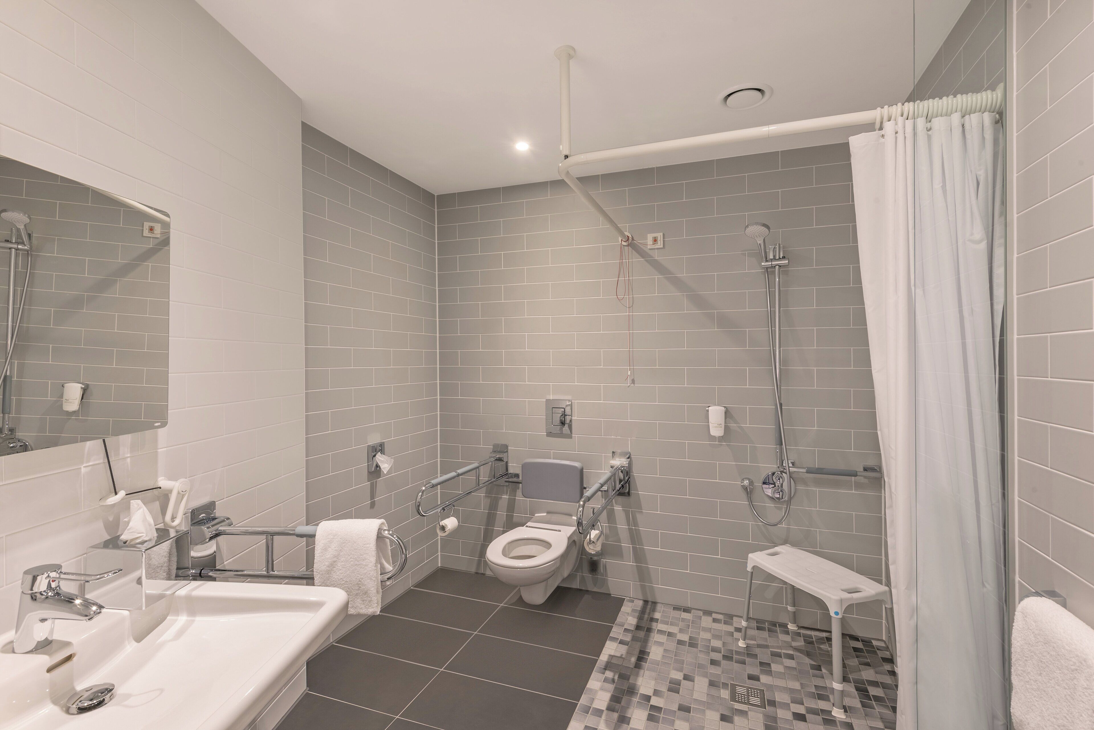 A modern bathroom with a toilet, sink, and shower.