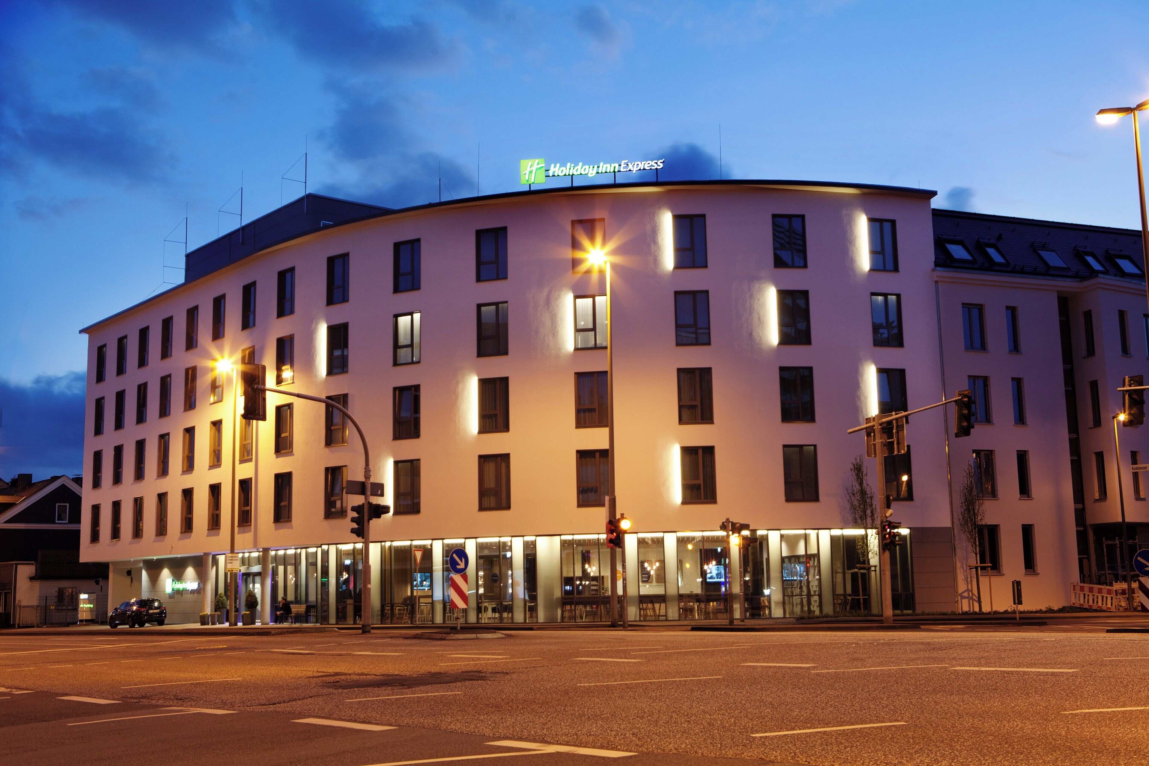 Et hotel med flere etager, en flad facade, oplyste vinduer og et skilt for Holiday Inn Express.
