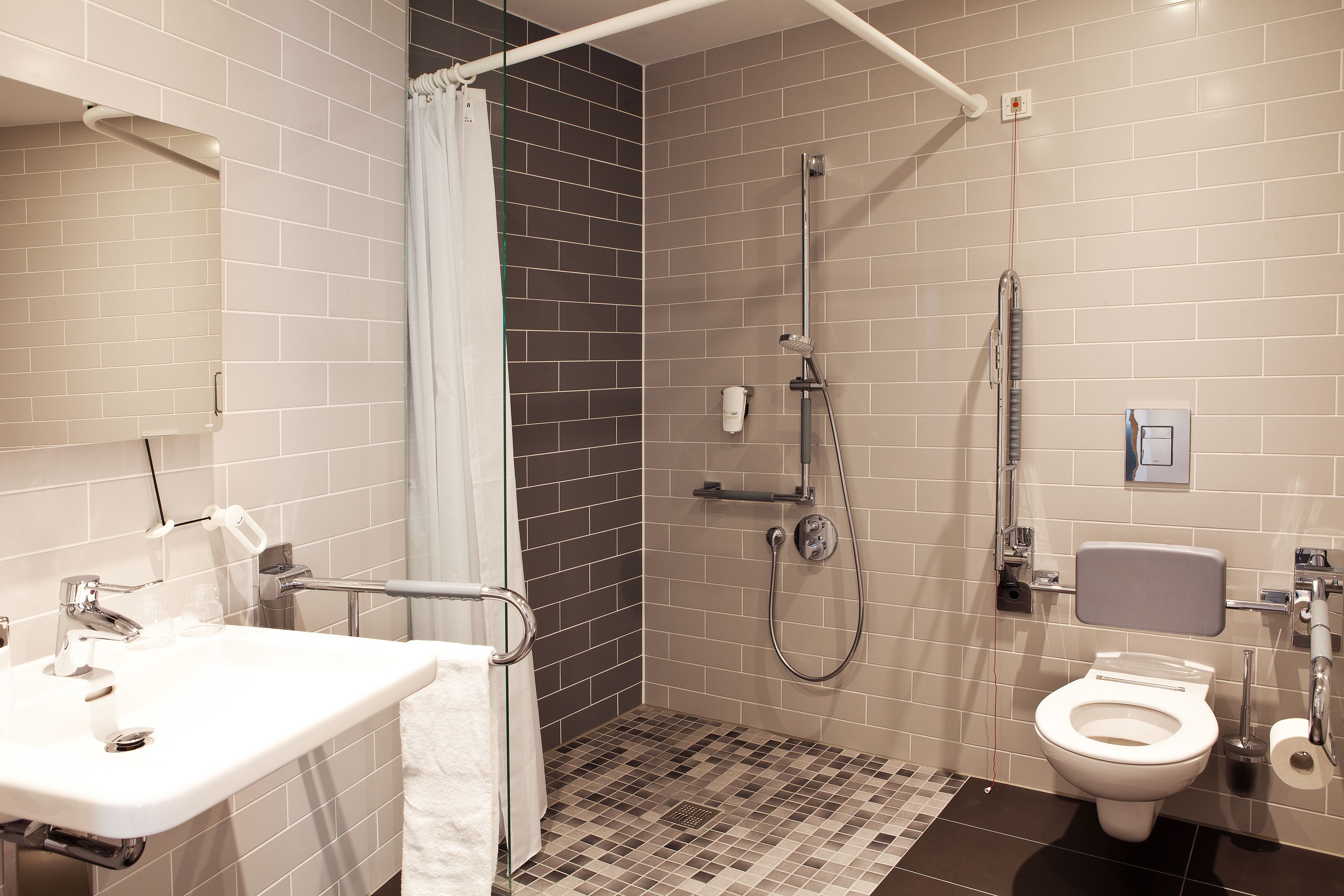 A bathroom with a shower, toilet, and sink.