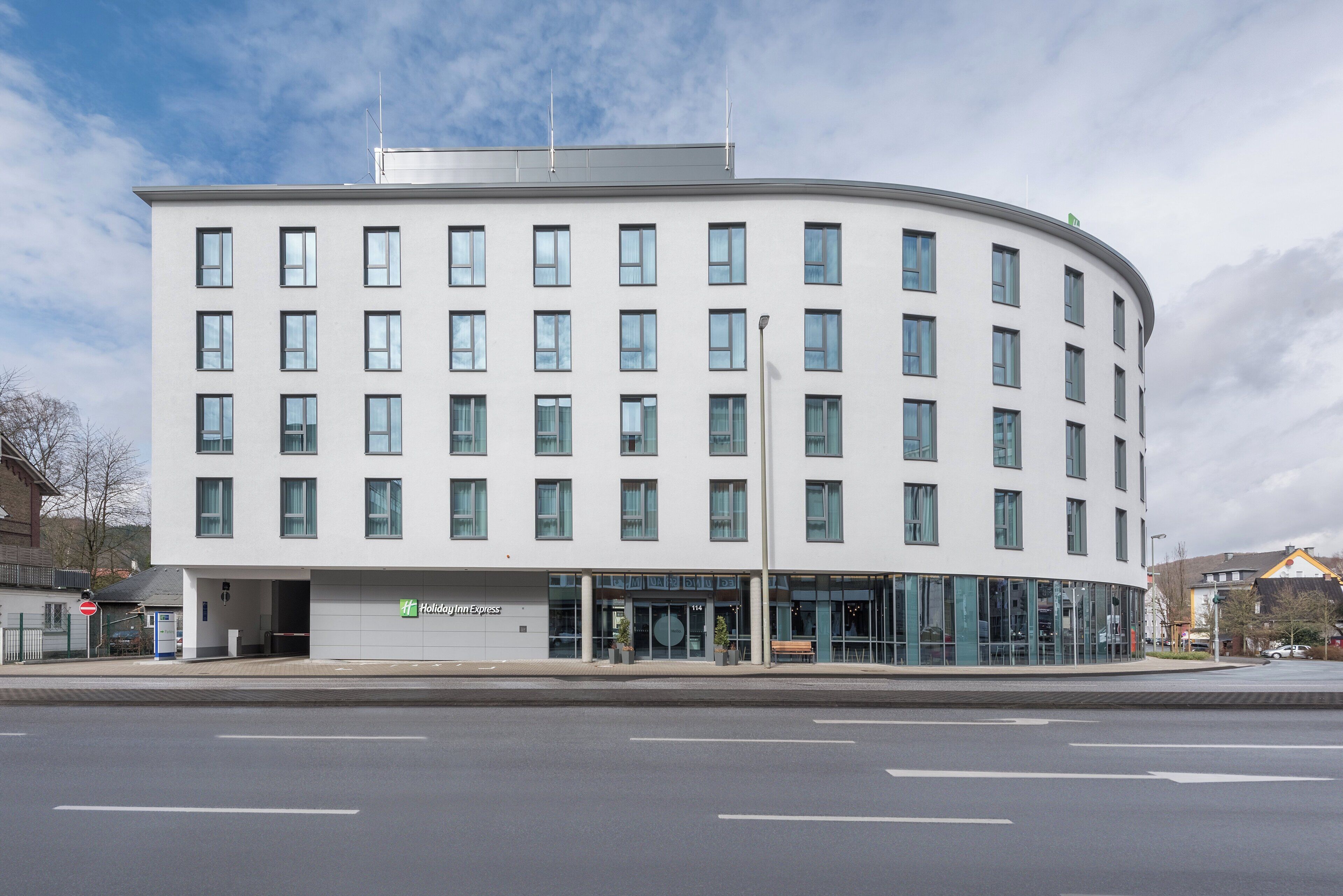 A modern hotel with a curved facade, multiple windows, and a Holiday Inn Express sign.