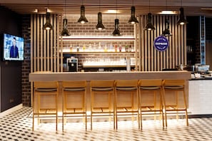 A bar area with wooden bar stools, pendant lighting, and a visible sign for 'EXPRESS Cafe & Bar'.