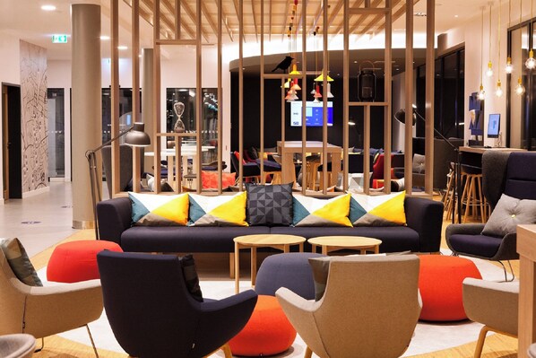 A modern lounge area with a sofa, chairs, and tables. - Holiday Inn Express Siegen by IHG (Siegen)
