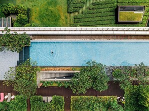 Vista aérea de un edificio moderno con piscina, terrazas verdes y zonas de estar al aire libre.