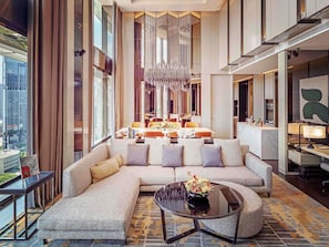A modern hotel lobby with a large sectional sofa, a round coffee table, and a chandelier. - Sofitel Singapore City Centre (Singapore)