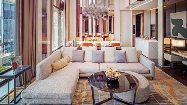 A modern hotel lobby with a large sectional sofa, a round coffee table, and a chandelier. - Sofitel Singapore City Centre (Singapore)
