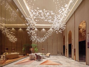 A modern lobby with a central seating area, a decorative ceiling installation, and a large mirror. - Sofitel Singapore City Centre (Singapore)