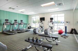 A gym with treadmills, weight machines, and exercise balls.