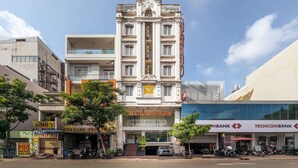 A multi-story building with a prominent entrance, a sign for 'CRATO BOUTIQUE', and adjacent commercial establishments including a bank.