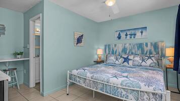 A bedroom with a bed, a desk, and a chair.