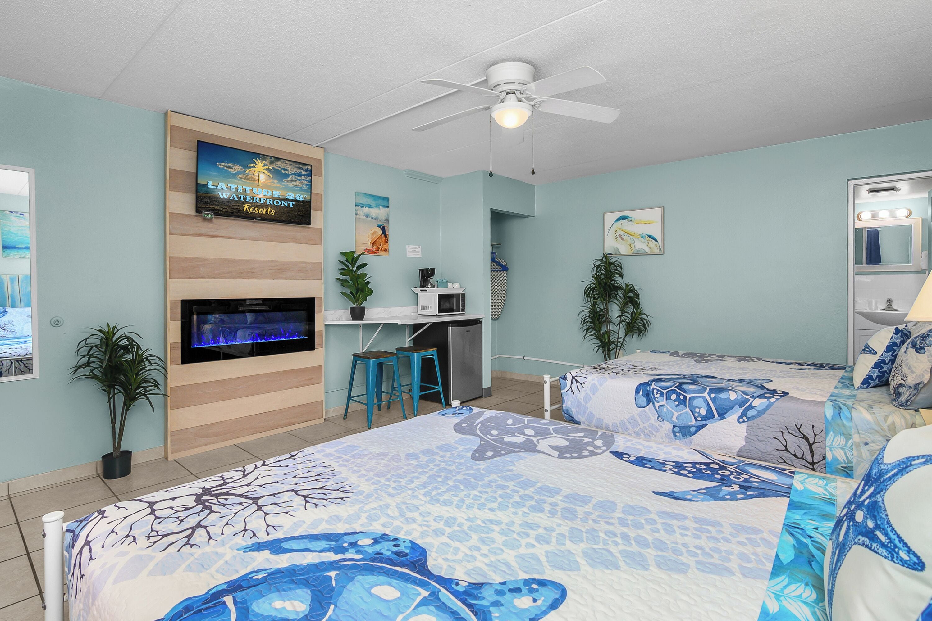 Un dormitorio con cama, escritorio, televisor y ventilador de techo.
