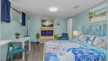 Una camera da letto con un letto, una televisione, una scrivania e delle sedie.