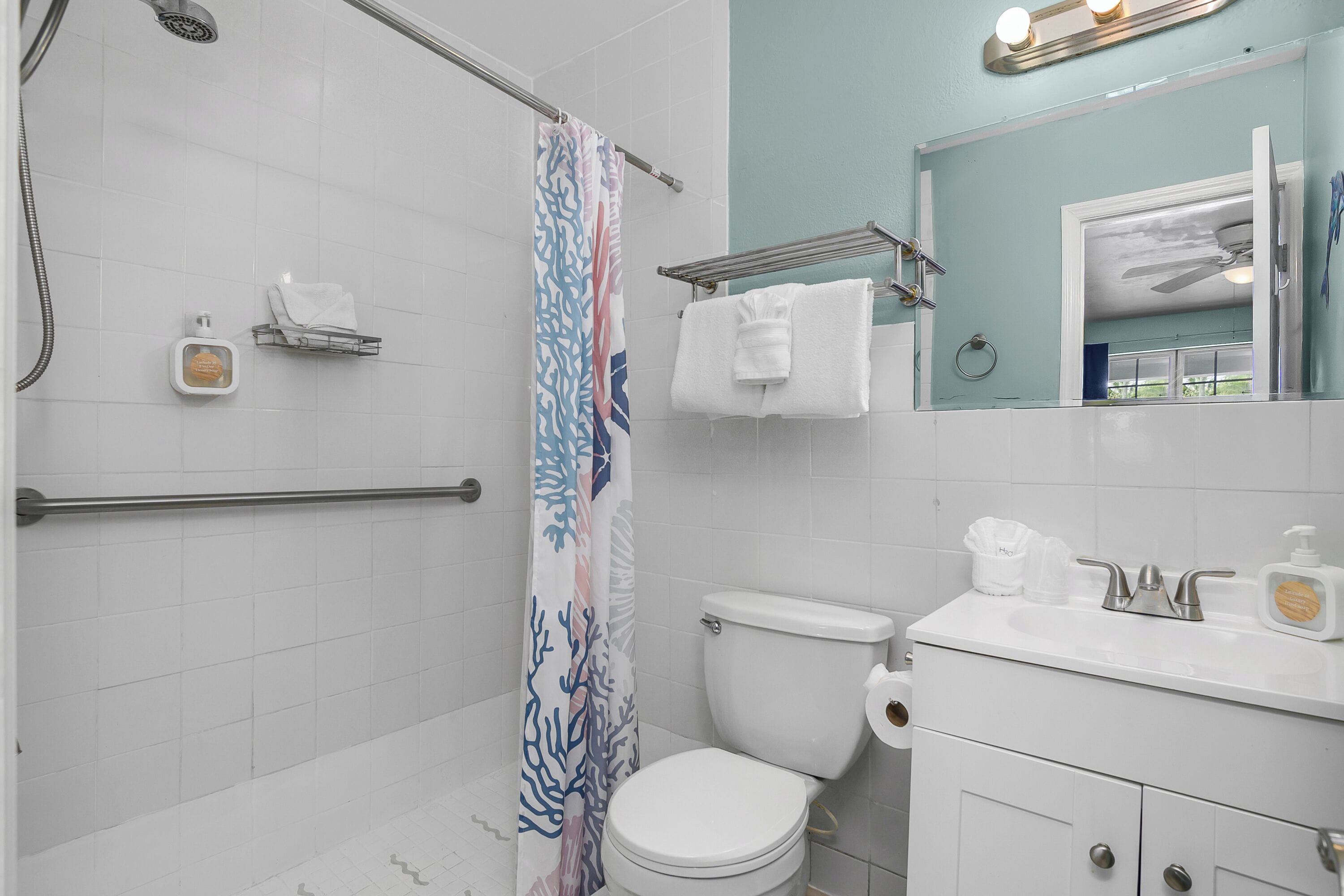 Une salle de bain équipée d’une douche, de toilettes, d’un lavabo et d’un miroir.