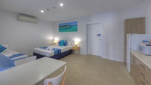 A modern hotel room with two beds, a dining area, and a kitchenette. - Bay Air Motel (Cleveland)
