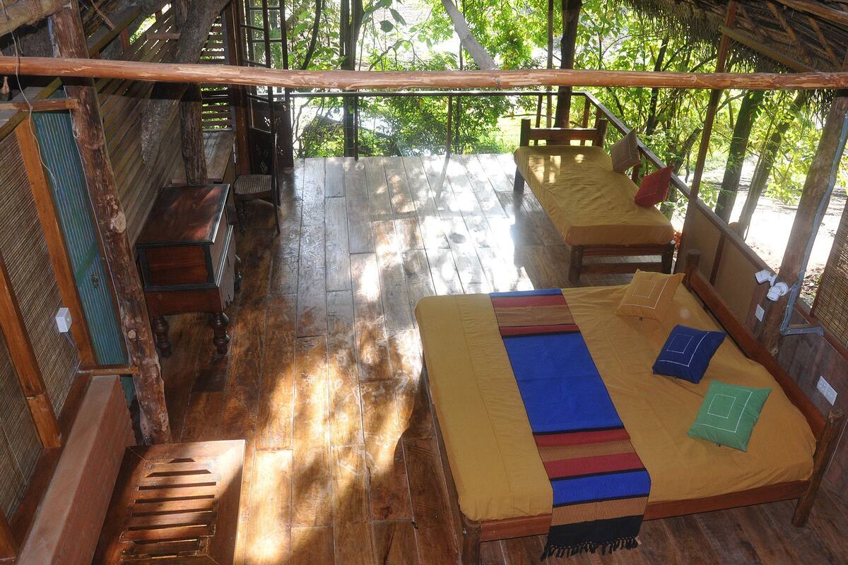 A wooden room with a bed, a bench, and a table.