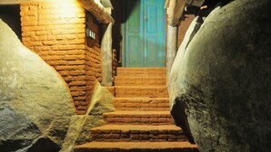 Un escalier en pierre menant à une porte dotée d’un cadre vert.