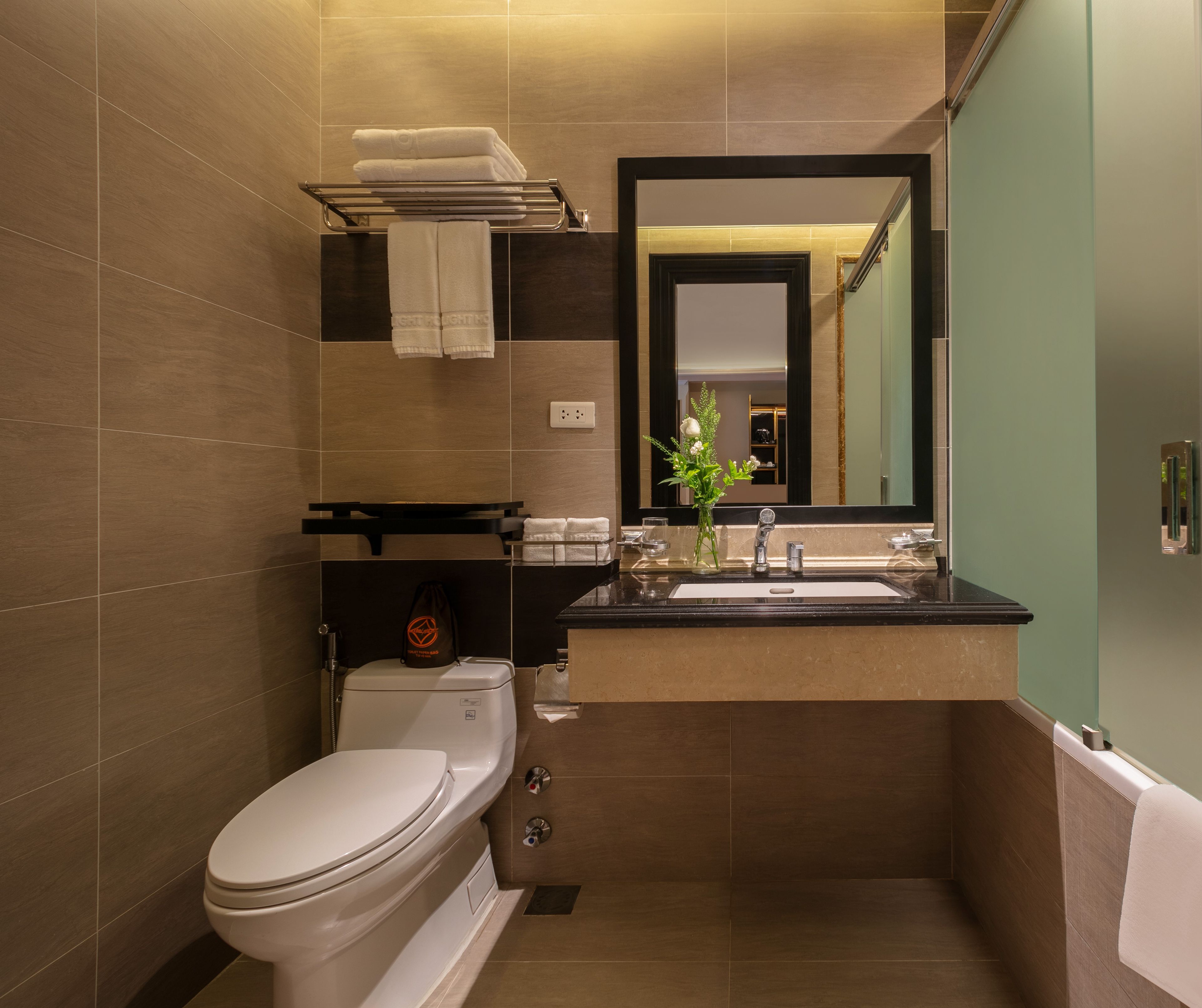 A modern bathroom with a toilet, sink, and mirror.