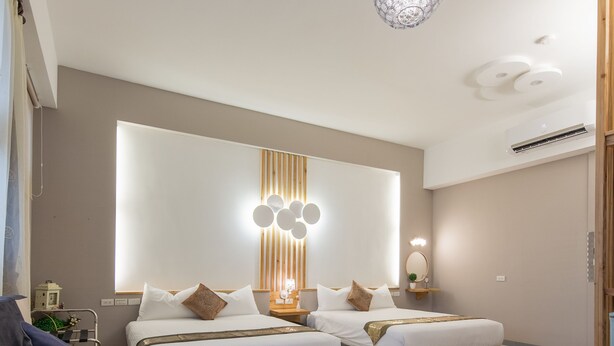 A modern hotel room with two beds, a sofa, a coffee table, and a decorative light fixture. - Kingdom Love Bed and Breakfast (Ji'an)