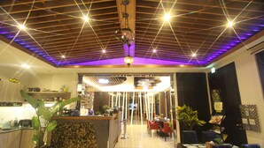 A restaurant with a wooden ceiling, a bar area, and a dining section with chairs and tables. - Kingdom Love Bed and Breakfast (Ji'an)