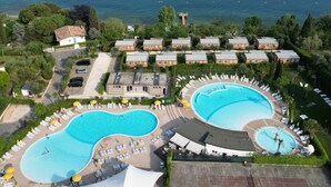 A resort with two swimming pools, a tennis court, and a view of the lake. - Camping Europa Silvella (Manerba del Garda)