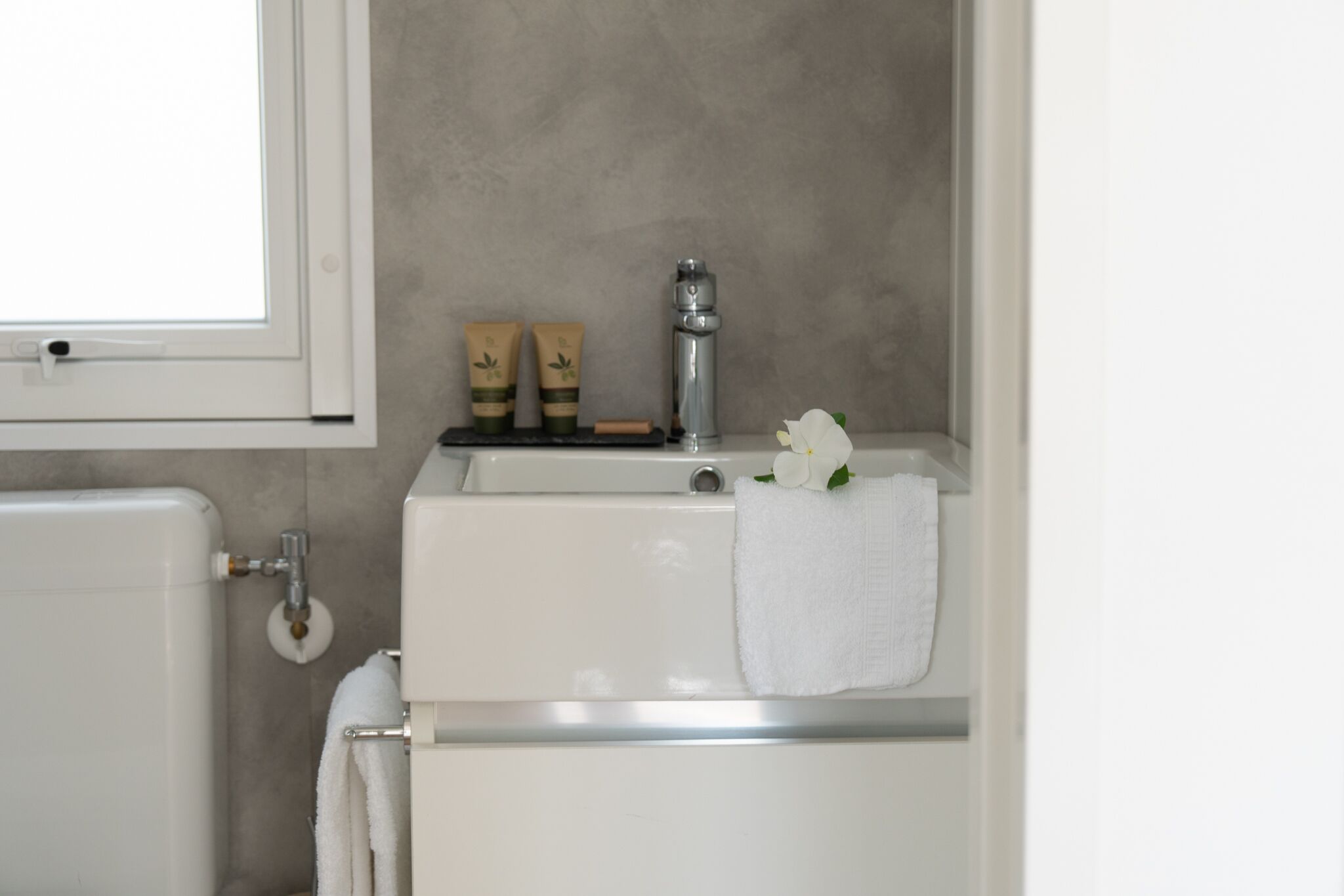 A bathroom with a white sink, a towel rack, and a toilet.