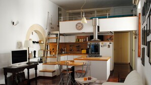 Un espacio habitable pequeño con kitchenette, comedor y sofá.