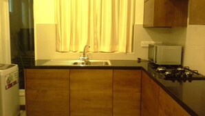 A compact kitchen with a sink, stove, and microwave. - Apartment by the Sea - Sea Ezta by Otium (Colombo)