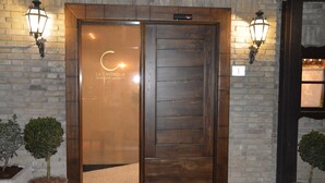 A wooden double door with a sign reading "LA CACCINELLA RESTAURANT". - La Cantinella (Ostra)