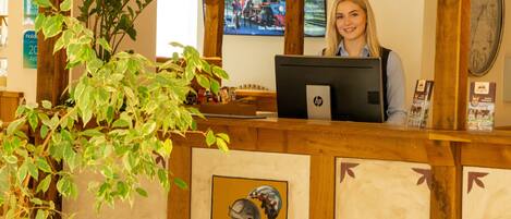 En reception med træramme, et skjold-emblem og en computerskærm.