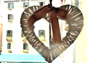 A heart-shaped decoration with a ribbon, hanging indoors. - Al Campaniel Apartment (Venice)