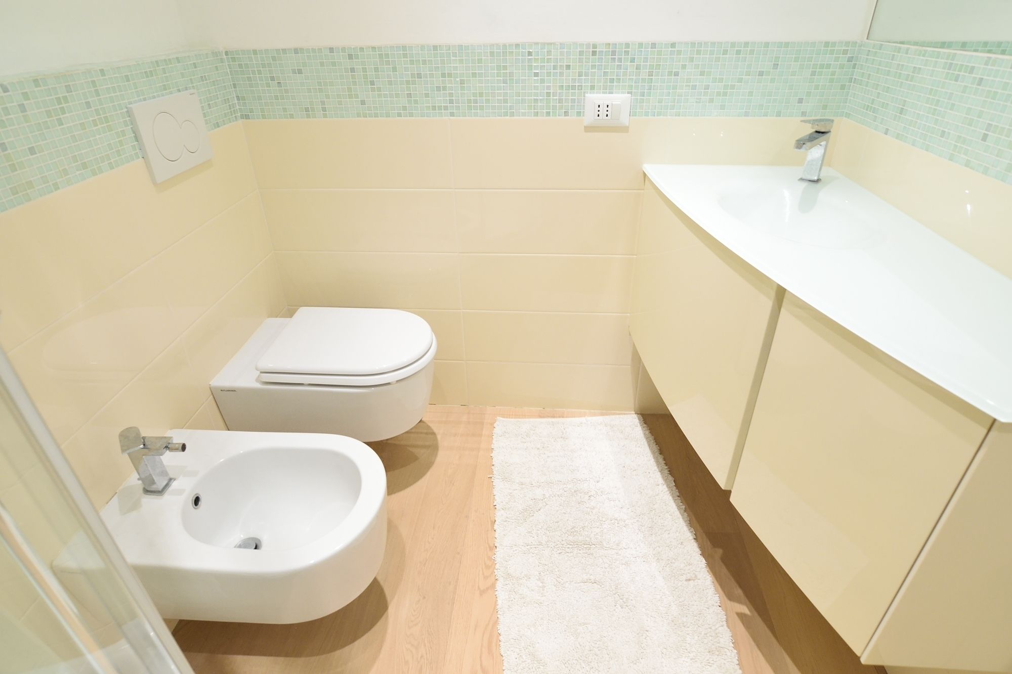 Un baño pequeño con inodoro, bidé y lavamanos.