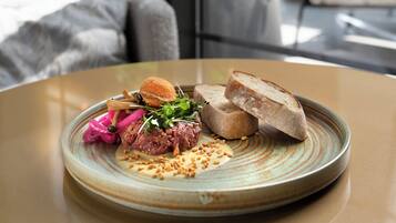 Un plato de comida con pan y ensalada sobre una mesa.