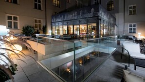A hotel lobby with a glass railing, seating area, and a view of the interior.